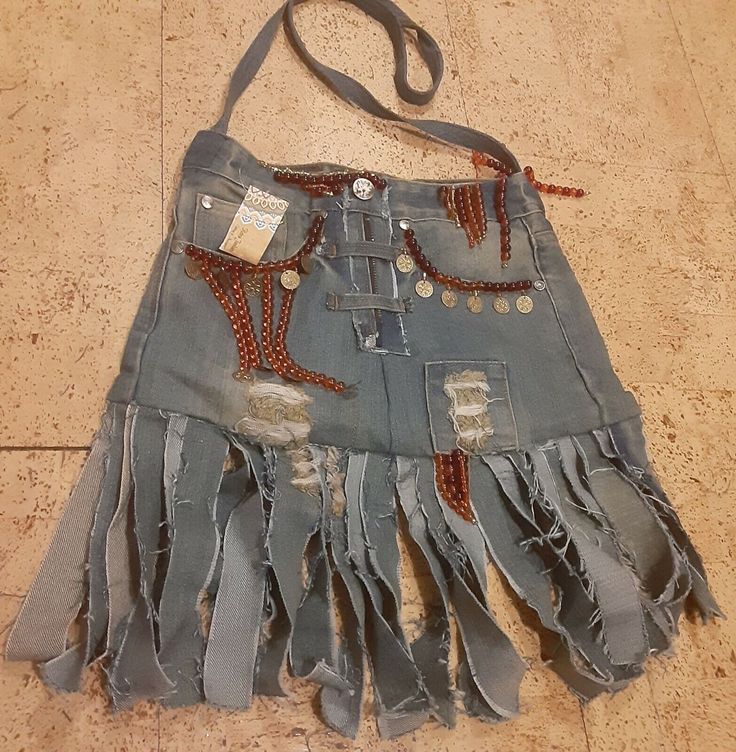 an old jean skirt with fringes and beads on the bottom is laying on the floor