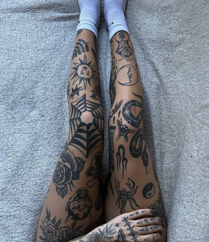 a person with tattoos on their legs laying down