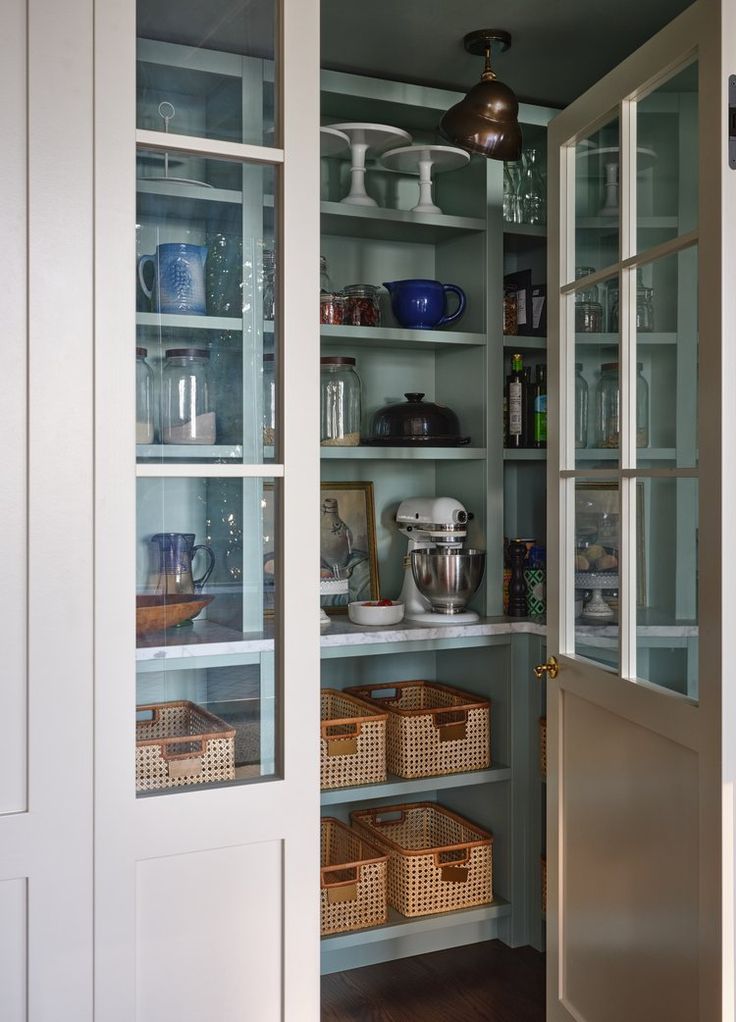 an open pantry with glass doors and shelves