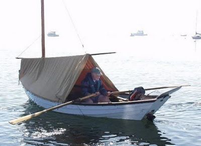 a man is sitting in a boat on the water with two oars and a tarp over his head