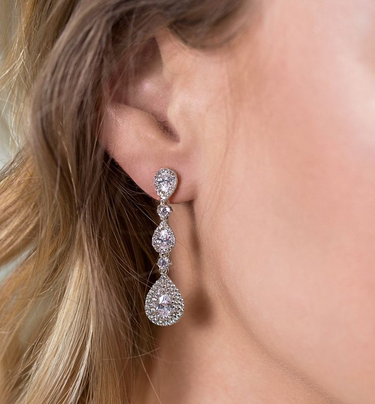 a woman's ear is shown with three diamond drops