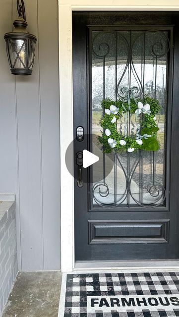 the front door is decorated with flowers and an iron gate that says, farmhouse house