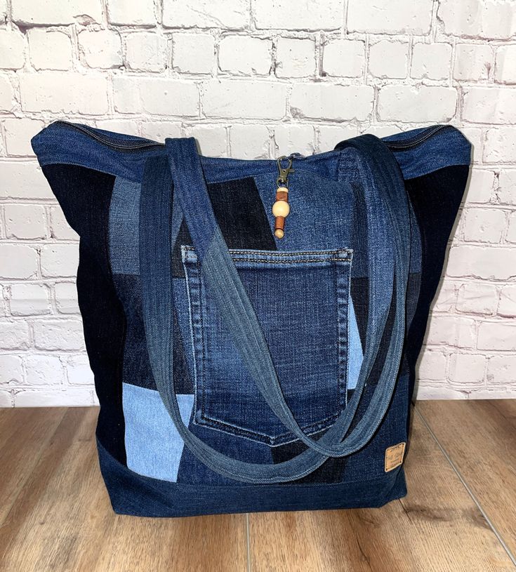 This Denim tote was made with several colors of denim giving it a fun, boho vibe. It has a double-pull top zipper that makes it perfect as a travel carryon. Jean back pocket on one side for an easy phone slot. It is lined with travel postage stamp print and has one interior zippered pocket. The two handles are 28" long making them perfect for your shoulder. Bag measures 15" tall x 12" wide x 6" deep. 75% of the fabrics I use in all my products are upcycled. I do this to keep them out of landfill Casual Dark Wash Shoulder Bag For Travel, Travel Shoulder Bag In Medium Wash Rectangular Shape, Travel Shoulder Bag With Pockets In Dark Wash, Trendy Recycled Denim Shoulder Bag For Everyday Use, Medium Wash Shoulder Bag With Pockets For Travel, Denim Blue Bags For Everyday Use, Casual Blue Bag With Zipper Pouch, Denim Blue Bags With Cell Phone Pocket For Everyday, Denim Blue Bags With Zipper Closure For Everyday Use