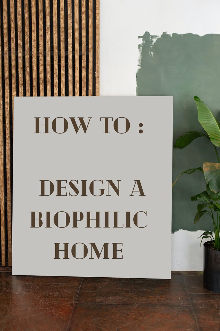 a sign that says how to design a biophicic home next to a potted plant