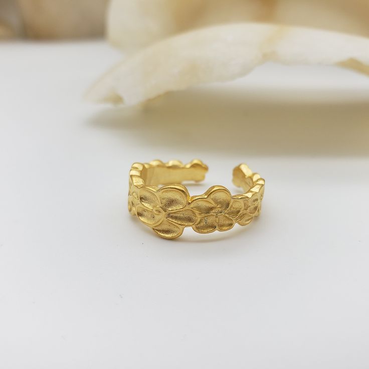 This ring draws inspiration from the intricate flower pattern adorning a Chinese bronze urn from the Qing Dynasty (1636-1912). Elaborate floral details form a simple and elegant design. Crafted from pewter and plated in 18K gold, it is an adjustable fit and made in the U.S.A. Materials: Pewter with 18K gold plating, nickel free Ring is adjustable - sizes 5-9. Made in USA Original design by Museum Reproductions Adjustable Gold Filigree Ring As Gift, Adjustable Gold Filigree Ring For Gifts, Elegant Gold Engraved Ring In Brass, Adjustable Gold Flower Ring, Bohemian Gold Flower Ring For Wedding, Handmade Gold Ring With Flower Shape, Vintage Adjustable Gold Flower Ring, Adjustable Gold Filigree Rings, Adjustable Vintage Gold Flower Ring