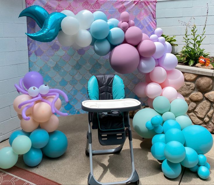 some balloons are on the ground near a baby's high chair