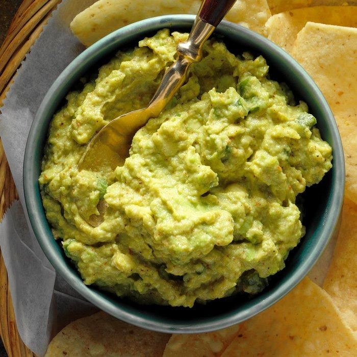 a bowl filled with guacamole surrounded by tortilla chips