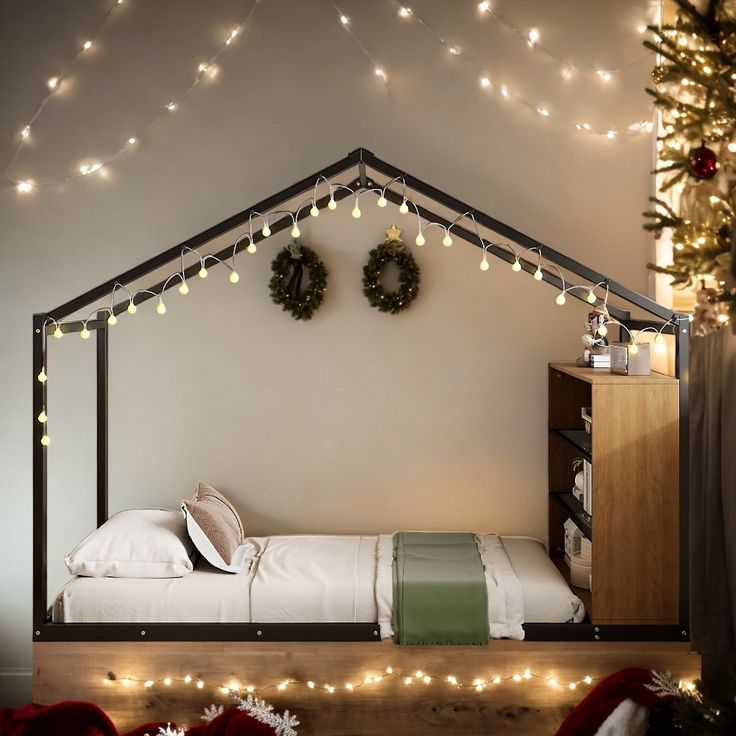 there is a bed with lights on the wall and christmas wreaths hanging above it