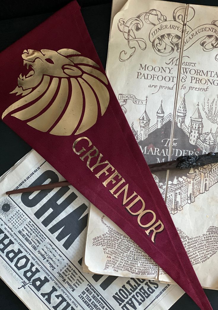 three harry potter themed pennants on top of each other, one with the hogwart's gryffindor logo