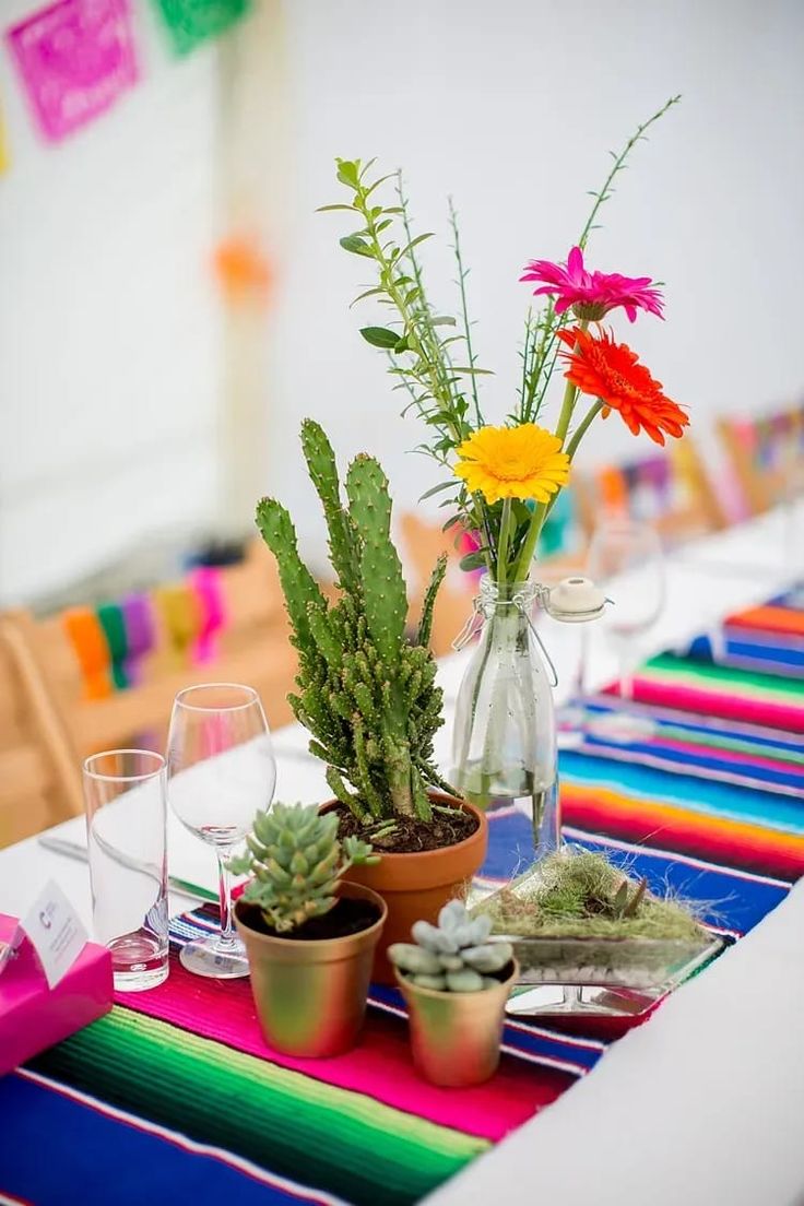 colorful table setting with flowers and succulents in vases on the table