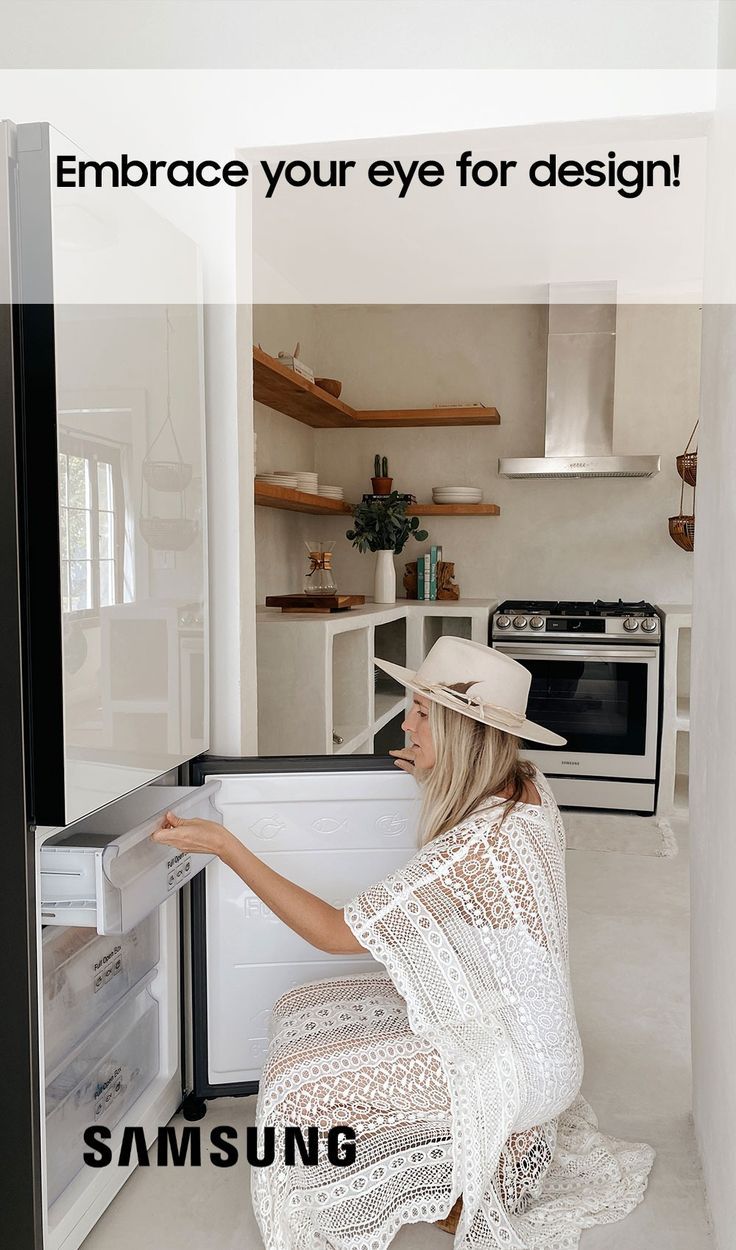 a woman kneeling down in front of an open refrigerator freezer with her hand on the door