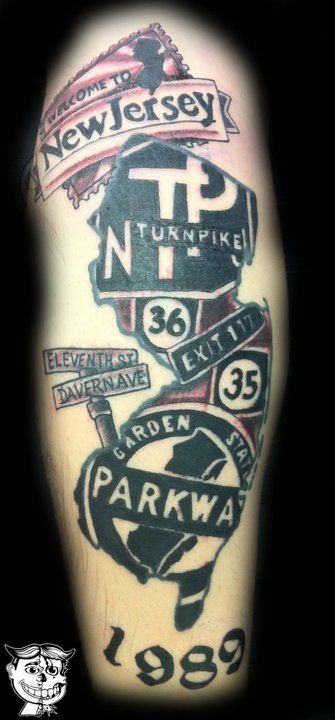 the back of a man's leg with tattoos on it and different street signs