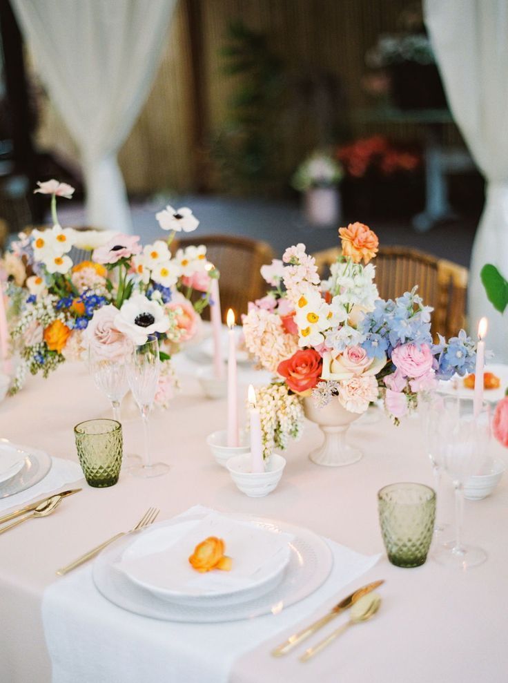 the table is set with flowers and candles for an elegant dinner party or wedding reception