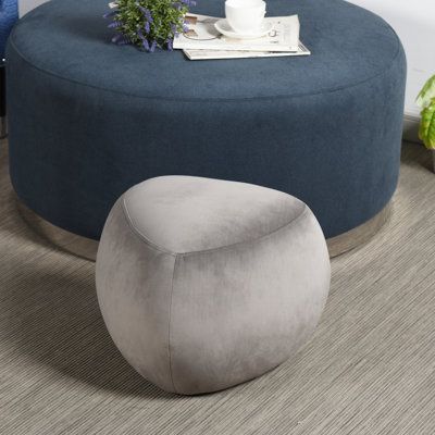 a large round ottoman sitting on top of a wooden floor next to a blue chair