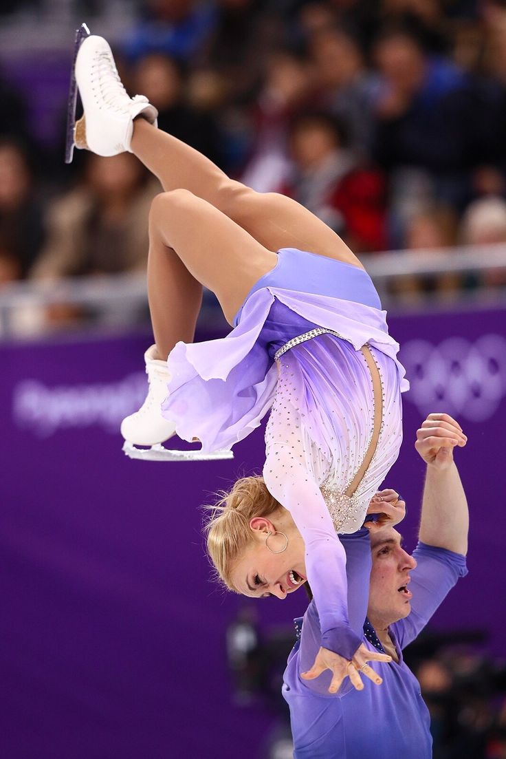 a man and woman are doing acrobatic tricks in front of an audience