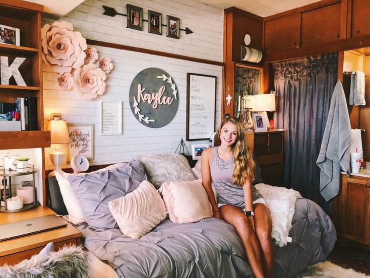 a woman sitting on top of a bed in a room with lots of furniture and decor