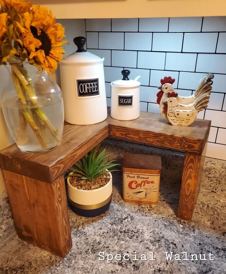 a wooden bench sitting on top of a kitchen counter next to a vase with flowers