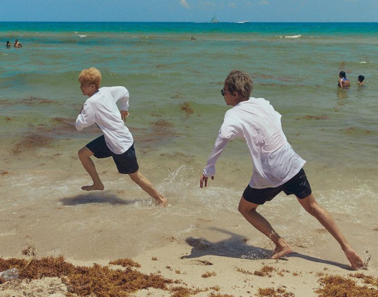 two men are playing in the water at the beach