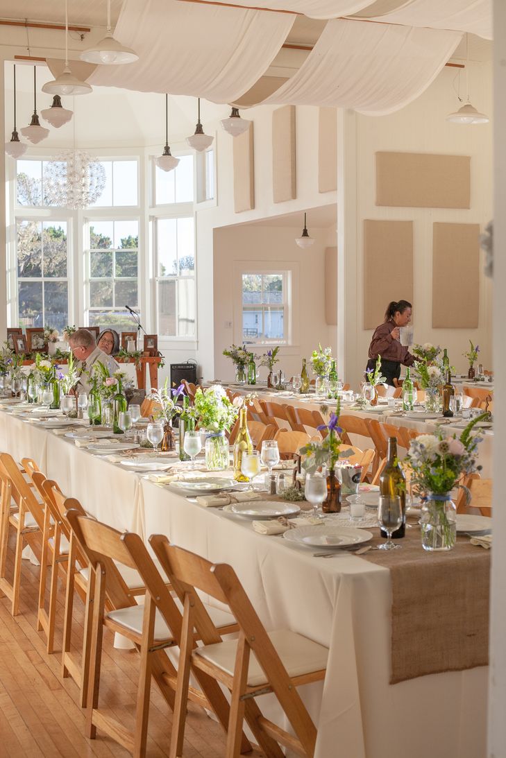 a long table is set up with flowers and wine bottles on it for a formal function