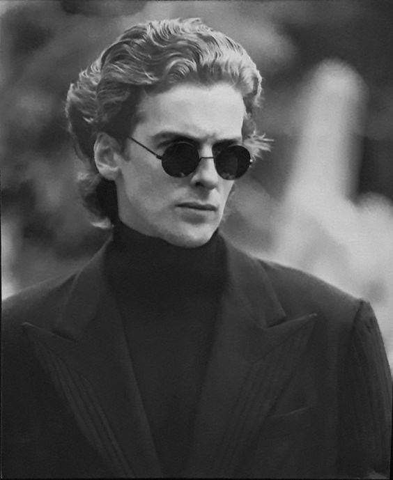 black and white photograph of a man in sunglasses looking off to the side while wearing a suit