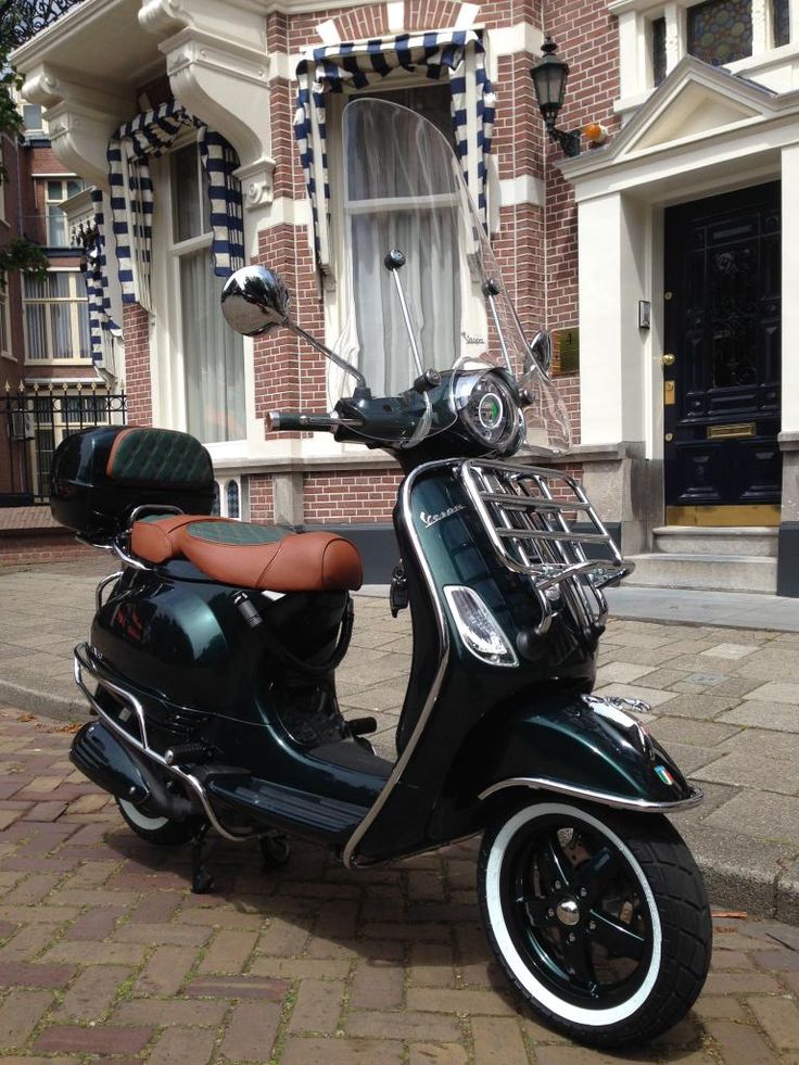 a scooter is parked on the side of the road in front of a building