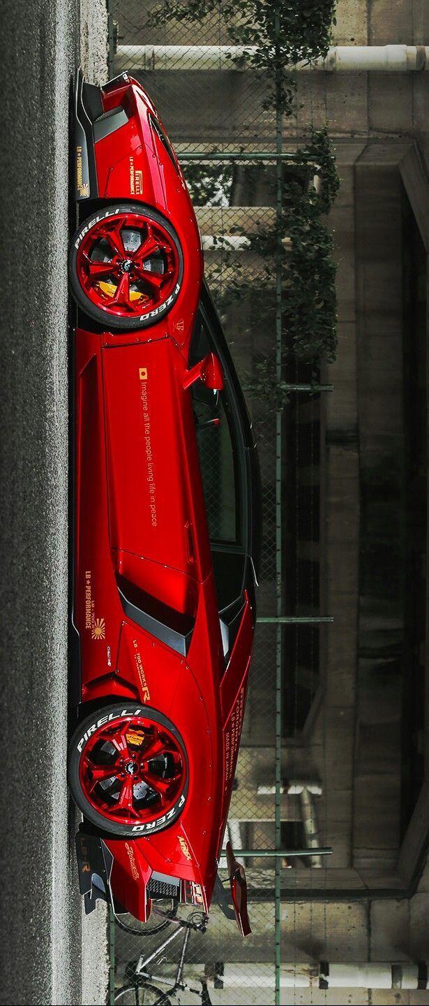 a red sports car parked on the side of a road next to a tall building