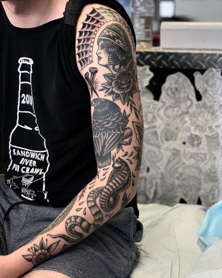 a man with a tattoo on his arm is sitting down and looking at the camera