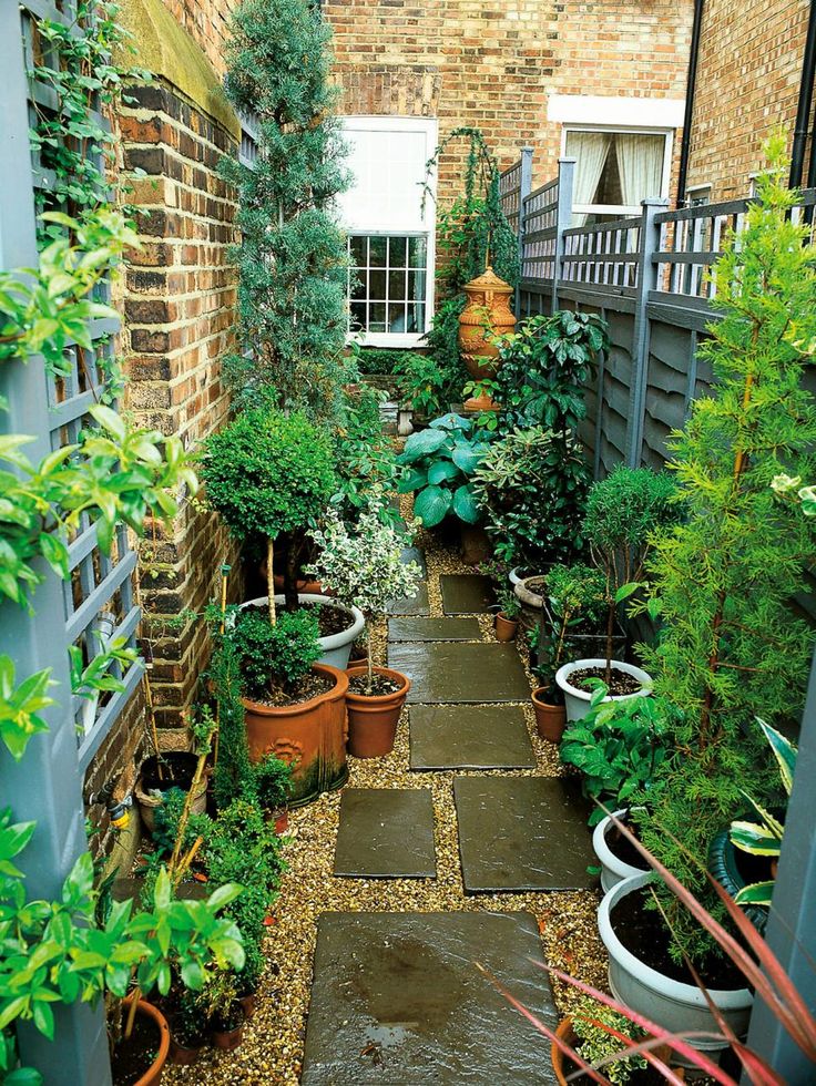 an outdoor garden with potted plants and stone walkway leading to the front door, surrounded by brick walls