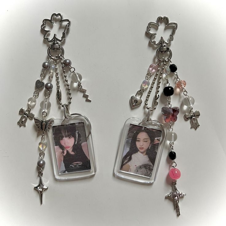 two necklaces with charms attached to them on a white surface, one has an image of a woman and the other is a cross