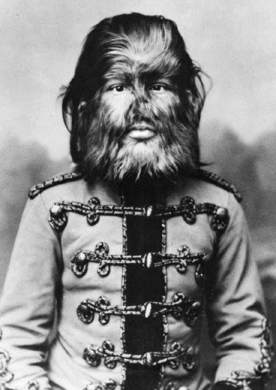 an old black and white photo of a man with long hair wearing a uniform that has chains on it