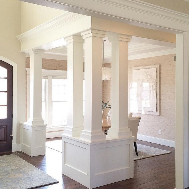 an empty living room with white columns and wood floors