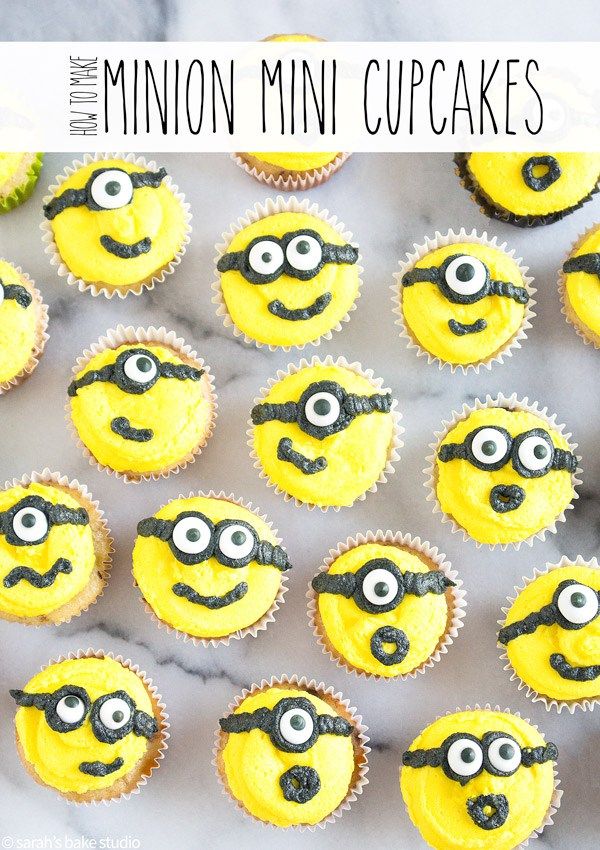 minion cupcakes with yellow frosting and green eyes on white marble counter top