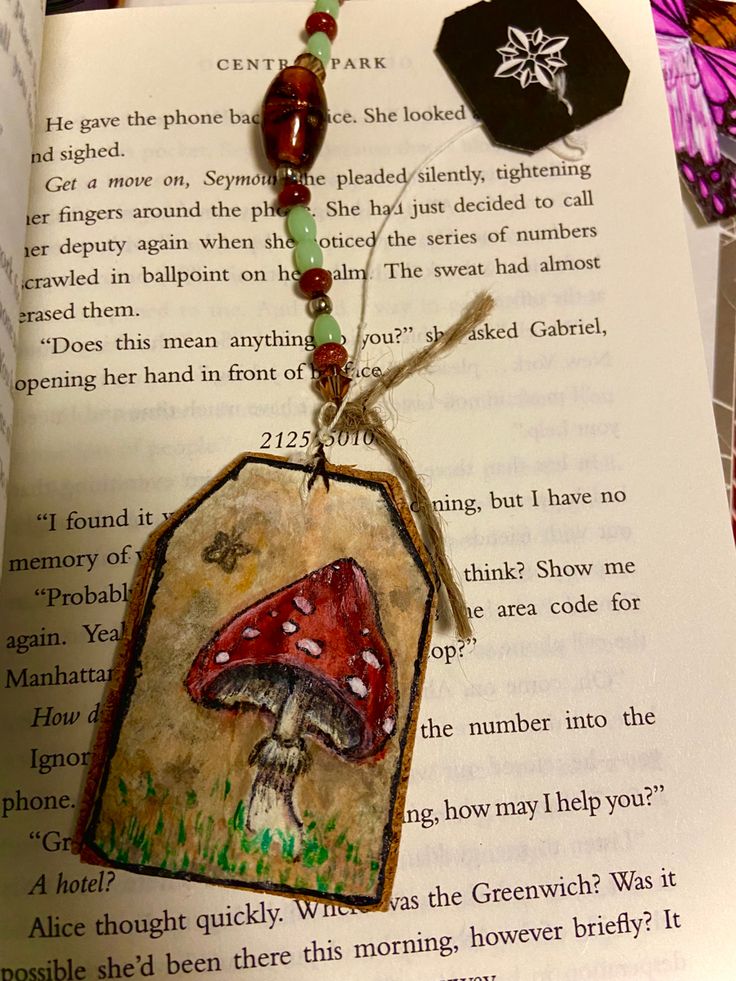 a book with an image of a red mushroom on it and a beaded necklace