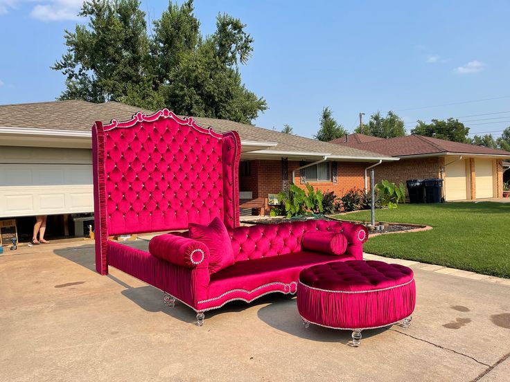 a pink couch and ottoman in front of a house