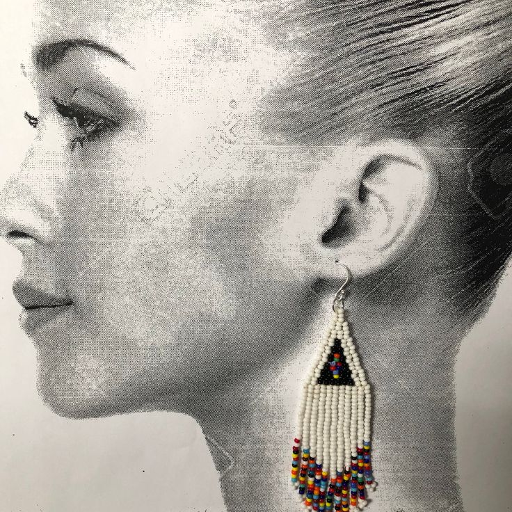 Handmade beaded white and multicolored seed bead earrings. Stunning handmade beaded earrings made with white and super bright multicolored 11/0 seed beads. The earrings have long flowing multicolored fringe. The french hook earwires and findings are sterling silver. These gorgeous Cheyenne style earrings are super long and brush your shoulders ever so slightly. Great for daywear and stunningly beautiful for the night out. Earrings measure approximately 4.5 inches including ear wires. Stylishly s Traditional White Beaded Fringe Jewelry, White Beaded Fringe Earrings For Festival, White Beaded Fringe Festival Jewelry, Festival White Beaded Fringe Jewelry, Bohemian White Beaded Fringe Earrings, White Bohemian Beaded Dangle Earrings, White Beaded Earrings With Round Tiny Beads, White Beaded Fringe Dangle Jewelry, White Beaded Chain Earrings