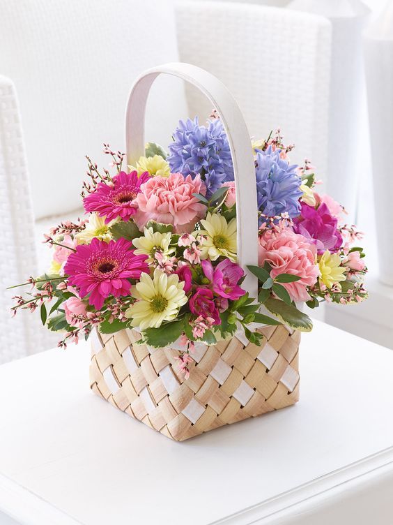 a basket filled with lots of flowers on top of a table