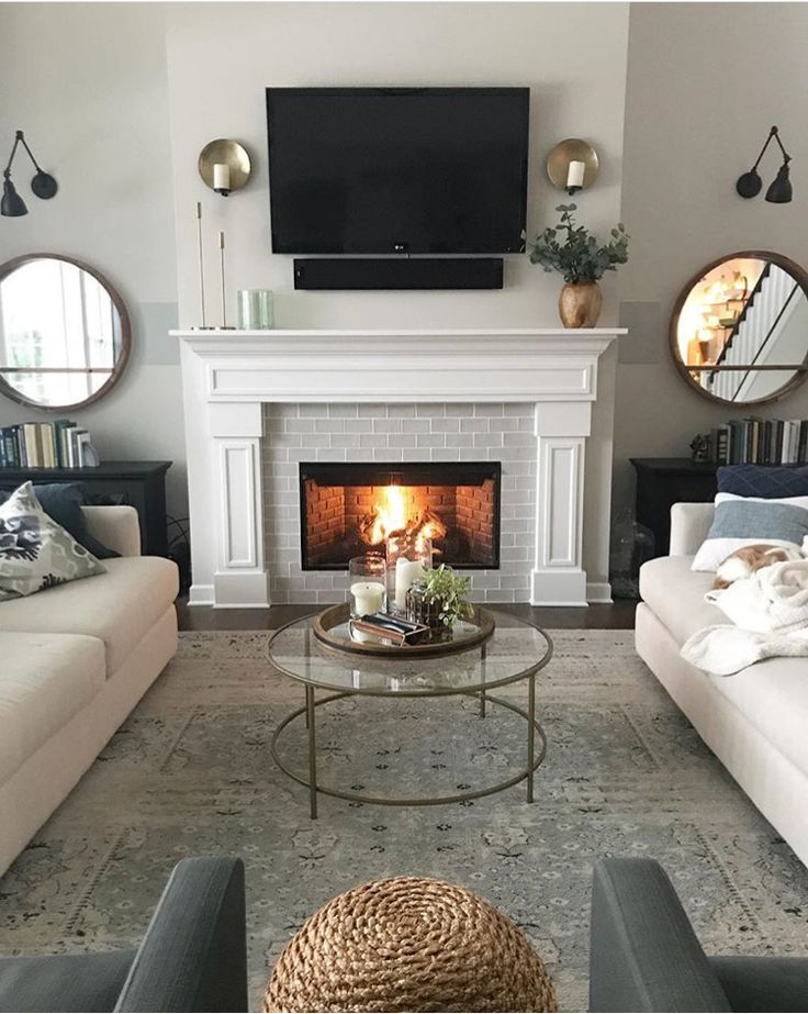 a living room with two couches and a fire place in the middle of it