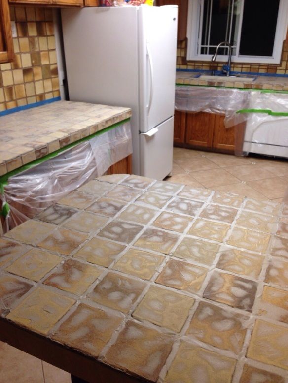 a white refrigerator freezer sitting inside of a kitchen next to a counter top covered in plastic