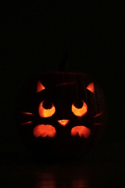 a carved pumpkin with glowing eyes in the dark