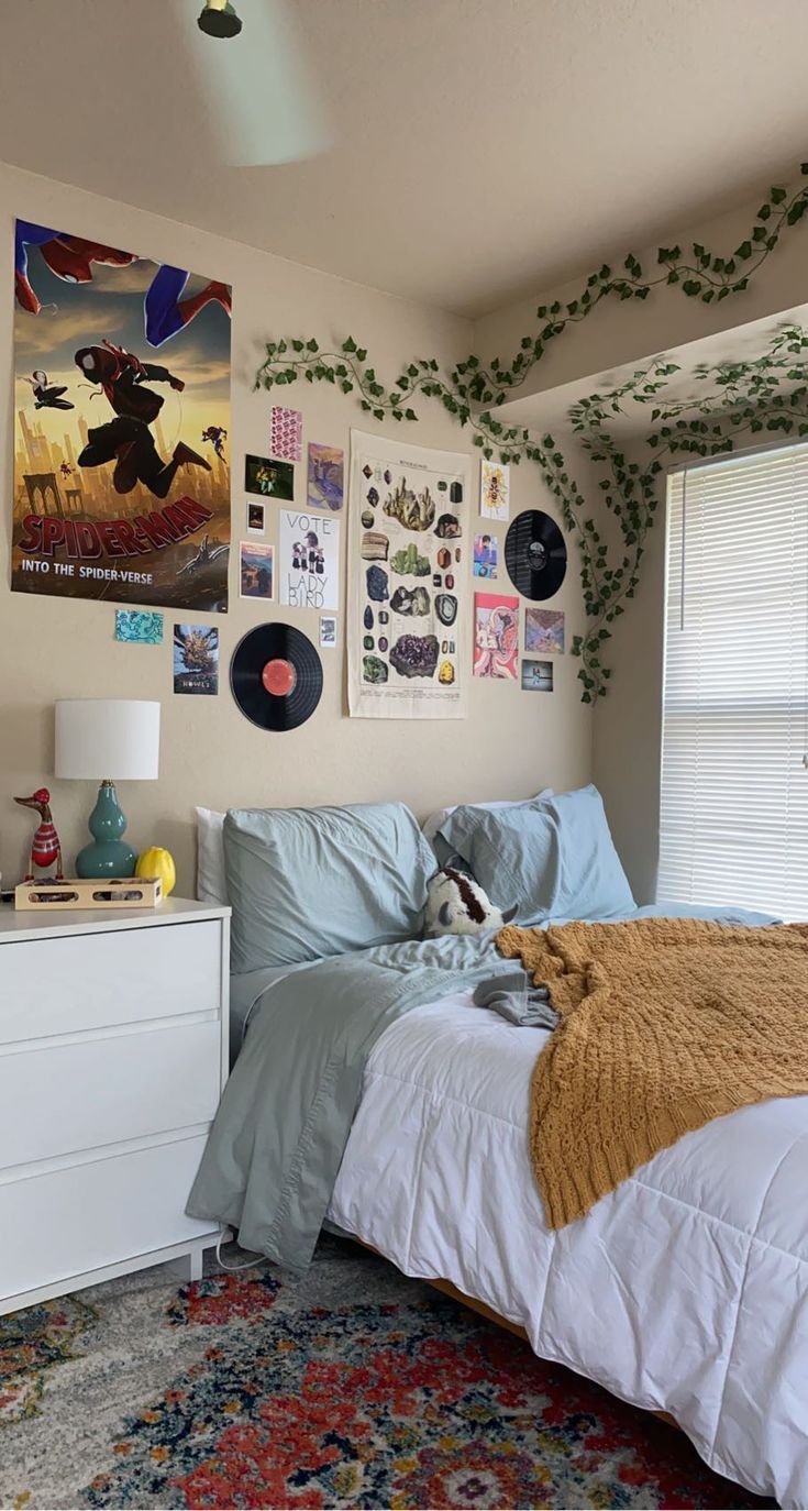 a bed room with a neatly made bed and lots of pictures on the wall above it