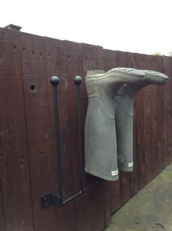 a pair of shoes hanging on the side of a wooden fence