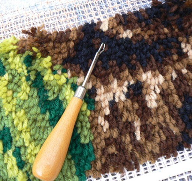 a crocheted dishcloth with a wooden spoon laying on it next to a knitting needle