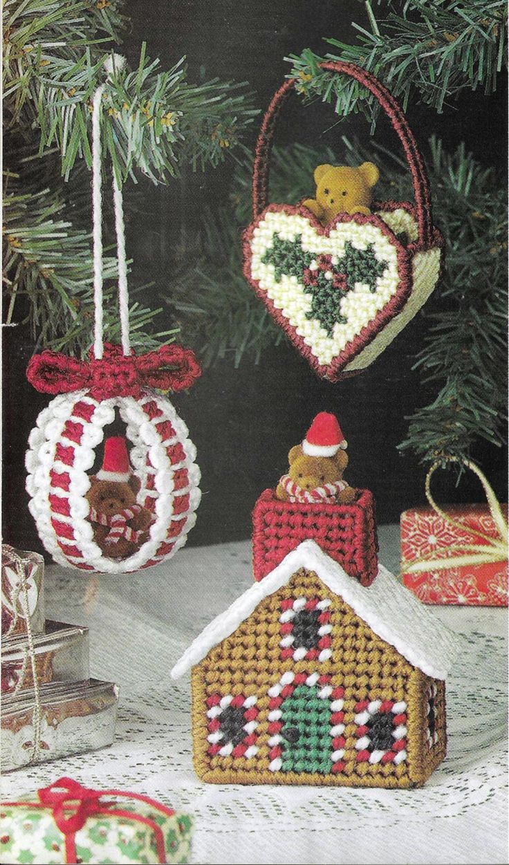 two christmas ornaments hanging from a tree in front of a holiday ornament with a teddy bear on top