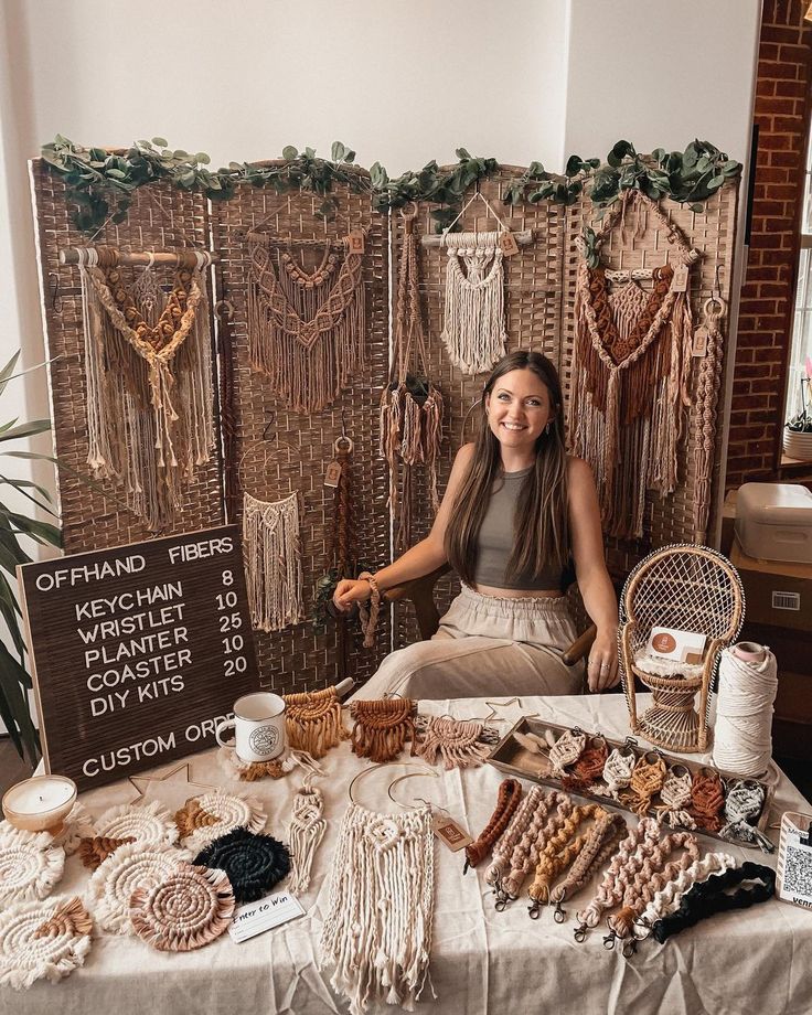 a woman sitting in front of a table filled with beads and other items for sale