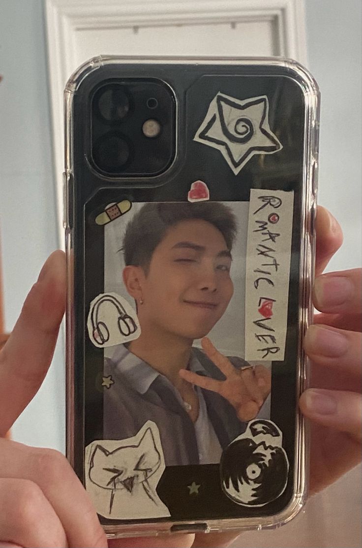 a person holding up a cell phone case with an image of a man on it