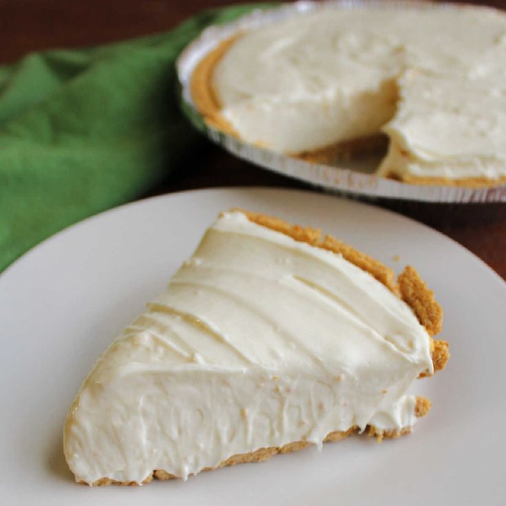 a piece of pie sitting on top of a white plate next to a green napkin