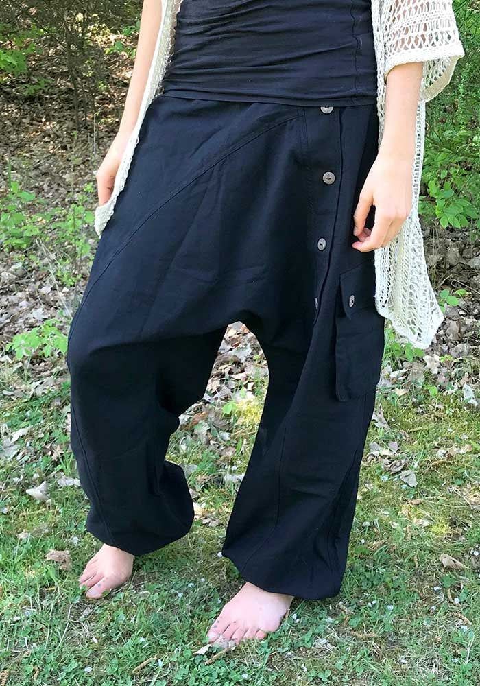 black bloomers out of heavy cotton fabric ॐ with two baggy bags and one regular pocket on the right leg. on the left leg is a raw of wooden buttons. it has an elastical waist band so it fits on perfect to your body. with the elastic bands on the ankles you can wear it as a short or 3/4 pants visually, this harem pants fits wonderfully with everything that is psychedelic, whether it's hippie, goa or psytrance parties, but also for yoga or meditation as well as in everyday life - with these comfor Black Cotton Yoga Pants With Loosely Fitted Hips, Bohemian Black Yoga Pants For Festivals, Black Cotton Hippie Harem Pants, Black Harem Pants With Pockets For Festival, Black Bohemian Yoga Pants For Festivals, Hippie Style Black Wide Leg Pants, Black Wide Leg Hippie Pants, Black Parachute Pants With Pockets For Festival, Black Cotton Harem Yoga Pants