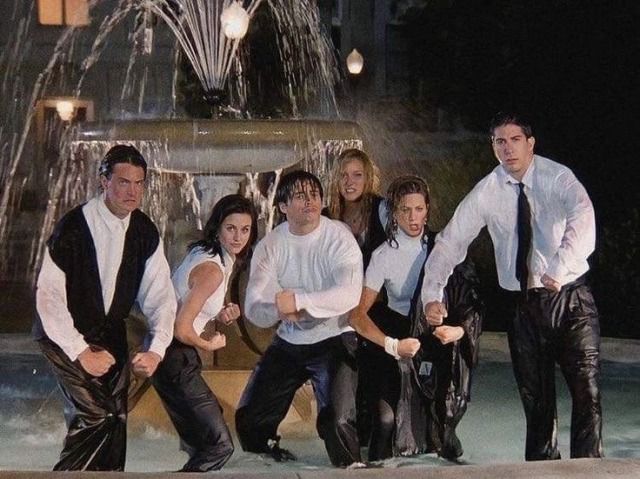 a group of people posing in front of a fountain