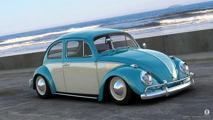 a blue and white vw bug parked in front of the ocean