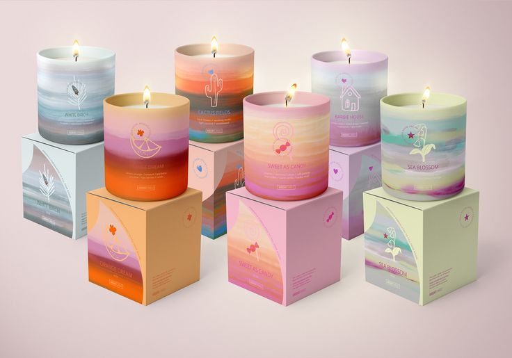 many different colored candles in boxes on a pink background